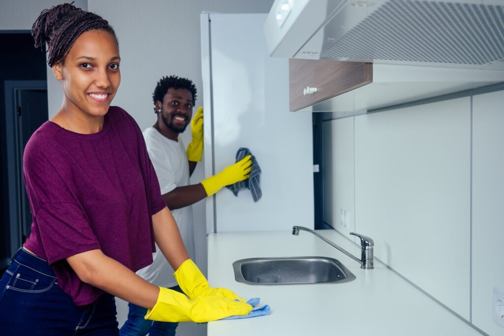 Man and woman cleaning the kitchen at home