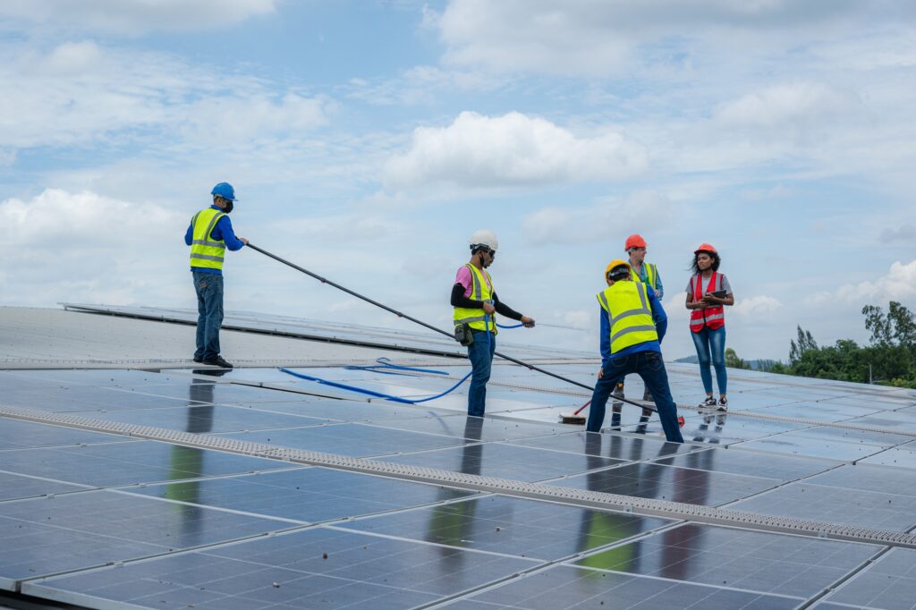 Solar power washing,labor working on cleaning solar panel at solar power plant.